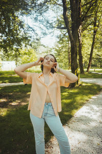 Fashionable young woman standing on footpath in park