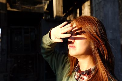 Close-up of woman shielding eyes