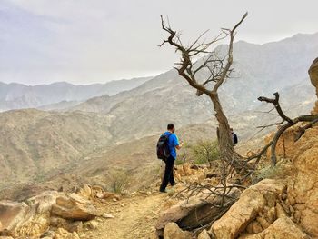 Rear view of hiker walking on mountain