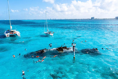 People snorkelling around the ship wreck near bahamas in the caribbean sea.