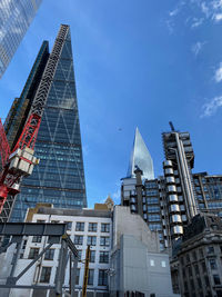 Low angle view of modern buildings against blue sky in the city of london