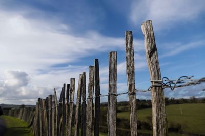 Wooden fence on field against sky