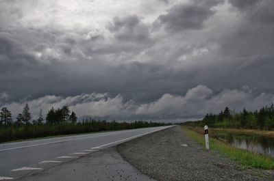 Road amidst field against sky