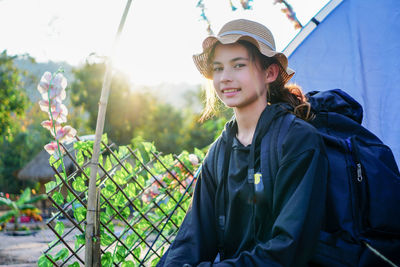 Woman backpacking sitting beside tent camping alone on vacation and mountain behind her