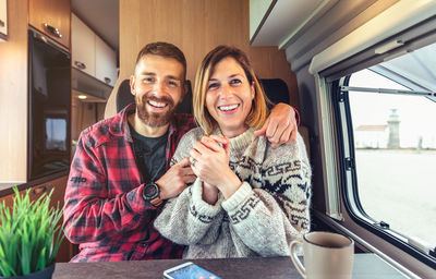 Happy couple talking looking at camera on video call from their camper van