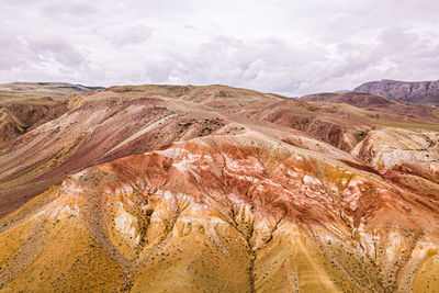 A stunning panorama of a mountain chain of peaks, a canyon with red clay, top view. 