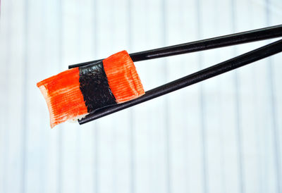 Close-up of chopsticks holding sushi