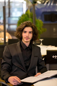 Portrait of businessman with menu at restaurant