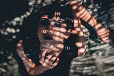 Portrait of young man holding sunglasses