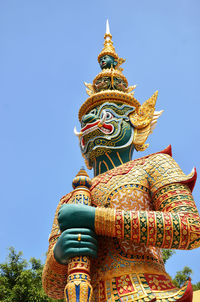 Low angle view of statue against blue sky