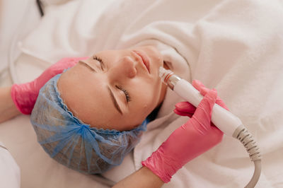 Young woman receiving facial microdermabrasion treatment