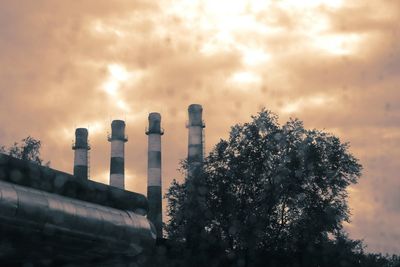 Smoke emitting from chimney against sky at sunset