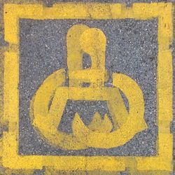 Close-up of yellow arrow symbol on road