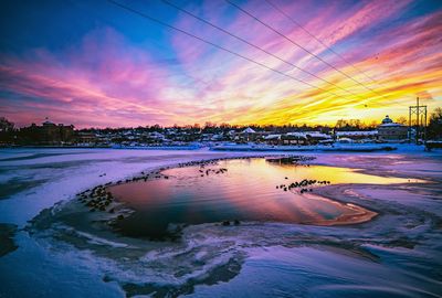 Scenic view of dramatic sky over city during sunset