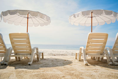Lounge chairs on sand at beach