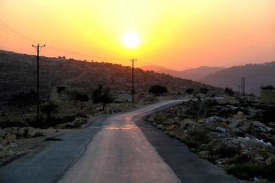 Road amidst landscape against sky during sunset