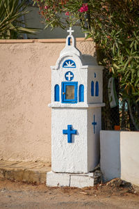 Greece, a typical small blue and white mini church with religious symbol cross to pray and remember