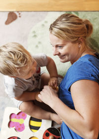 High angle view of mother playing with baby at home