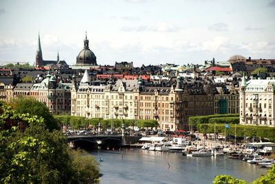 Boats in river with city in background