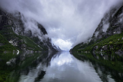 Scenic view of lake amidst mountains against sky