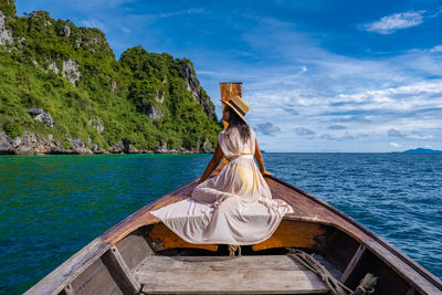 Rear view of woman in sea against sky