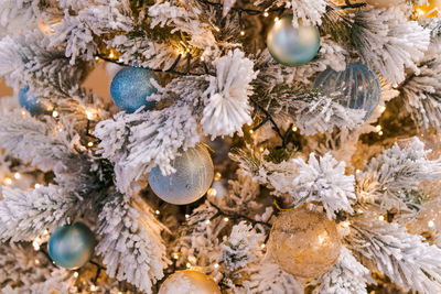 Christmas tree with beautiful decor on the branches close up, holiday concept