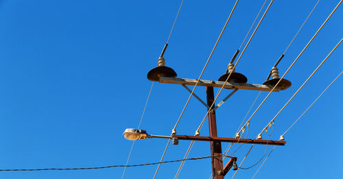 Low angle view of chain swing ride against clear blue sky