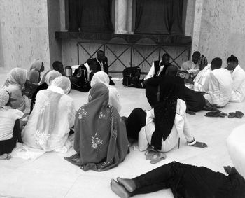 High angle view of people discussing while sitting at mosque