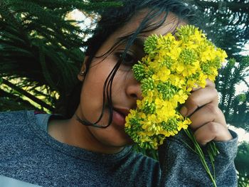 Close-up of woman holding yellow flowering plant