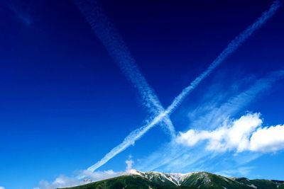 Low angle view of vapor trail against blue sky