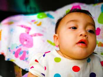 Close-up portrait of cute baby on bed