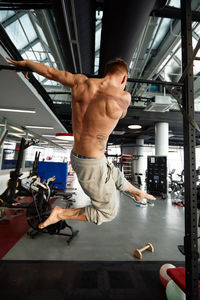 Shirtless man exercising in gym