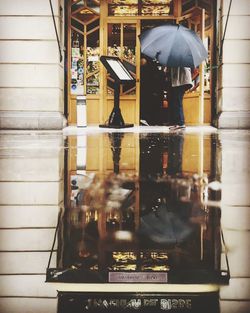 Reflection of people on building in city