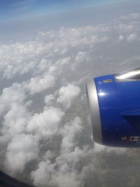 Close-up of airplane wing against cloudy sky