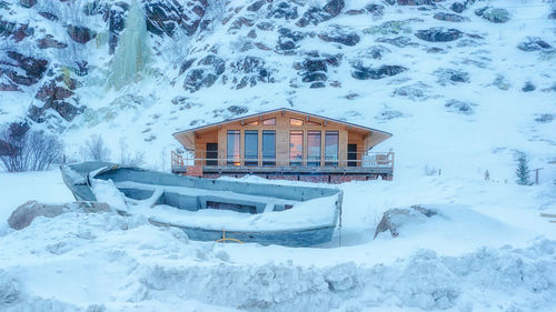 Snow covered house by building