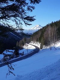 Scenic view of snow covered mountains against blue sky