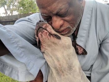 Close-up of man embracing dog