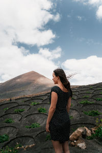 Full length of woman standing against mountain and sky