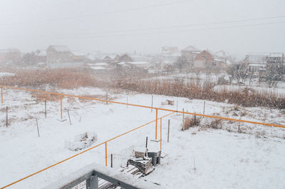 Snow covered railroad tracks by building during winter