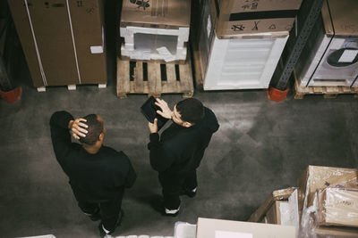 High angle view of male worker discussing over digital tablet at warehouse