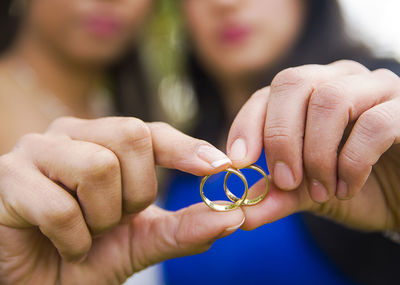Midsection of couple holding wedding rings