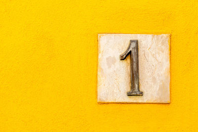 Close-up of number 1 on yellow wall