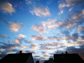 Low angle view of silhouette roof against sky