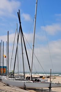 Sailboats moored in sea against sky