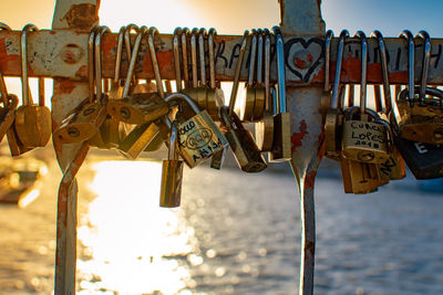 Close-up of love padlocks hanging on bridge against sky