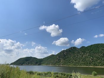 Scenic view of lake by mountains against sky