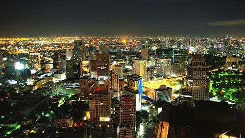 Illuminated cityscape against sky at night