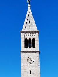 Low angle view of clock tower against clear blue sky