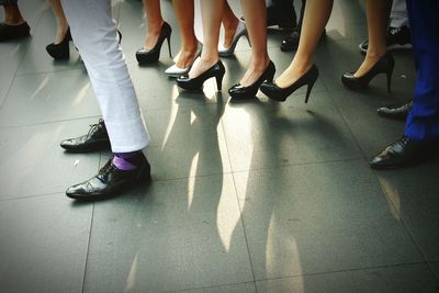 Low section of people standing on tiled floor