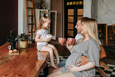 A happy cheerful family with a child is cooking dinner together in the kitchen at home